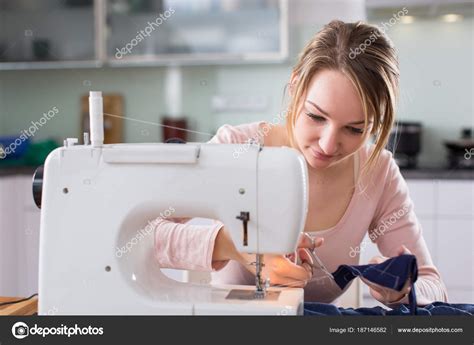 beautiful young woman sewing clothes  sewing machine stock photo