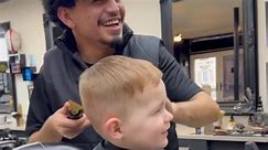 Adorable kid can't stop laughing while getting his hair trimmed