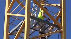 Tower crane climbing: Man climbing in tower