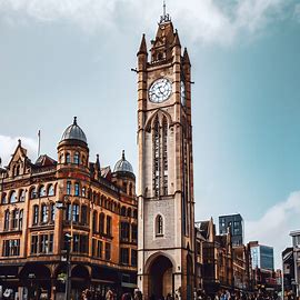 An old manchester clock tower standing tall and proud in the center of the bustling city. Image 4 of 4