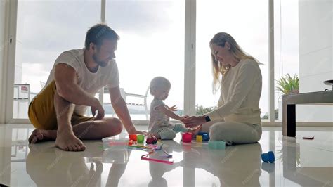 Mamá y papá jugando con una niña en juegos educativos en el piso | Foto ...