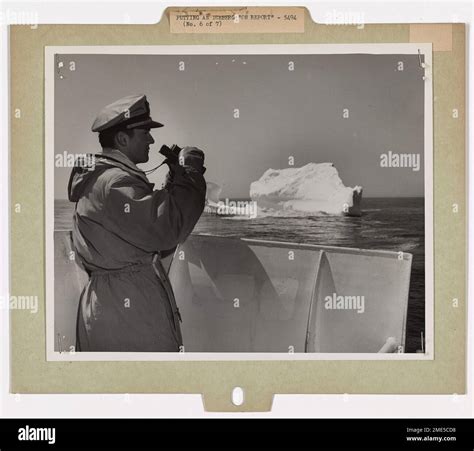 A U.S. Coast Guard officer on the International Ice Patrol examines an ...