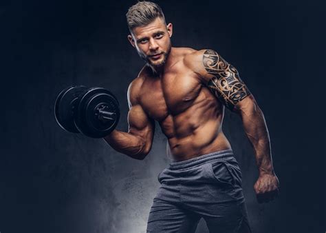 Poderoso fisiculturista elegante com tatuagem no braço, fazendo os ...
