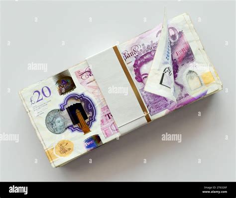 A bundled wad of british pound banknotes on an isolated light ...