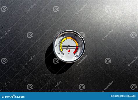 A Round Thermometer Showing 200 Degrees Celsius Placed on a Charcoal ...