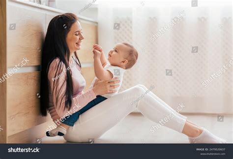 Woman Seated On Floor Cradling Baby Stock Photo 2479520637 | Shutterstock