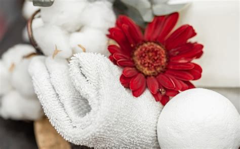 Bath towel and bath bomb and red flower. hygiene and health concept ...