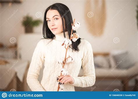 Young Woman in Knitted White Dress Sweater with a Branch of Cotton ...