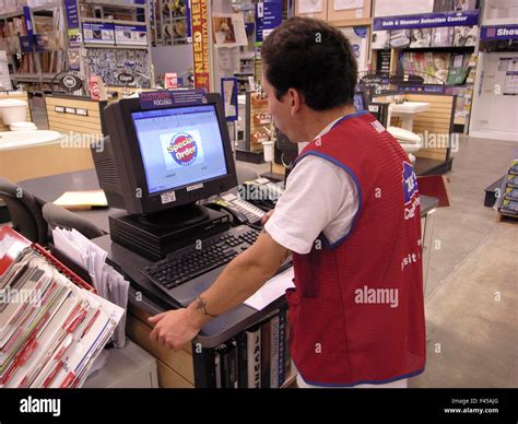 An Asian American salesman places a special order using a computer at a Lowe's building material ...