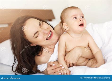 Young Funny Mom Playing the Ape Her Baby Crying Lying in Bed at Home ...