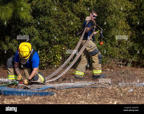Horry County firefighters set up fire hoses as they monitor the ...