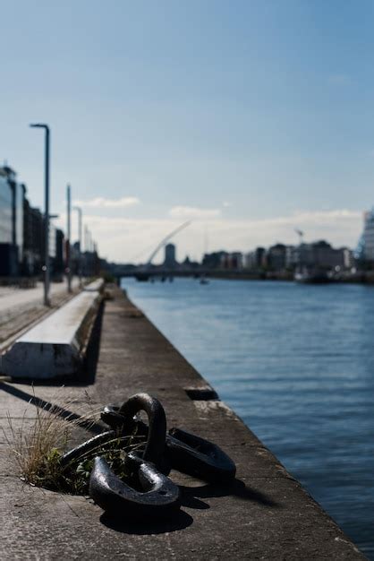 Close-up of metal post by river in city against sky | Premium Photo