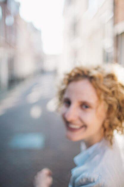 Cheerful woman walking on street in city | Premium Photo