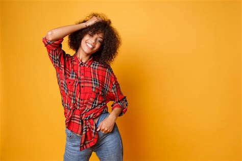 Optimistic laughing black woman posing in studio on orange background ...
