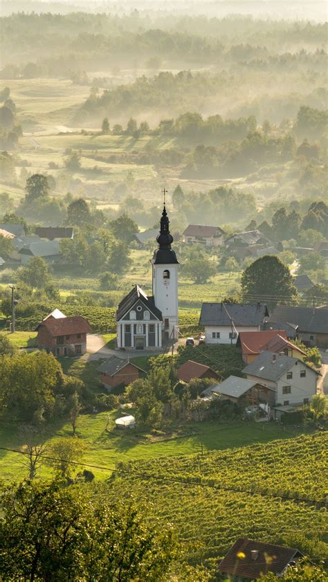 Download wallpaper 800x1420 chapel, houses, buildings, valley, fog ...