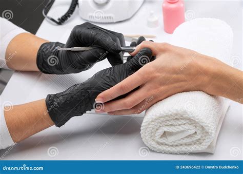 A Manicurist Removes Cuticles during a Nail Extension Procedure in a ...