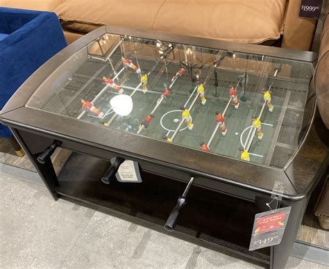 A coffee table with a foosball game inside of it. Sit down and play ...