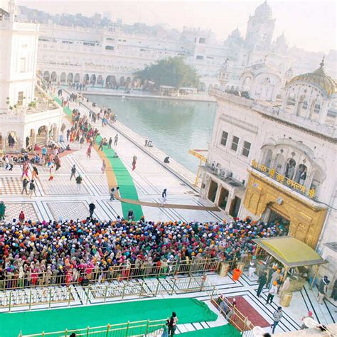 Sikh devotee plays a musical instrument as he walks with Punj Pyara ...