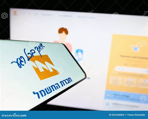 Mobile Phone with Logo of Utility Company Israel Electric Corporation (IEC) on Screen in Front ...