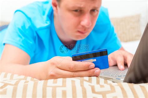 男人拿着蓝银行卡躺在床上高清图片下载-正版图片303296543-摄图网