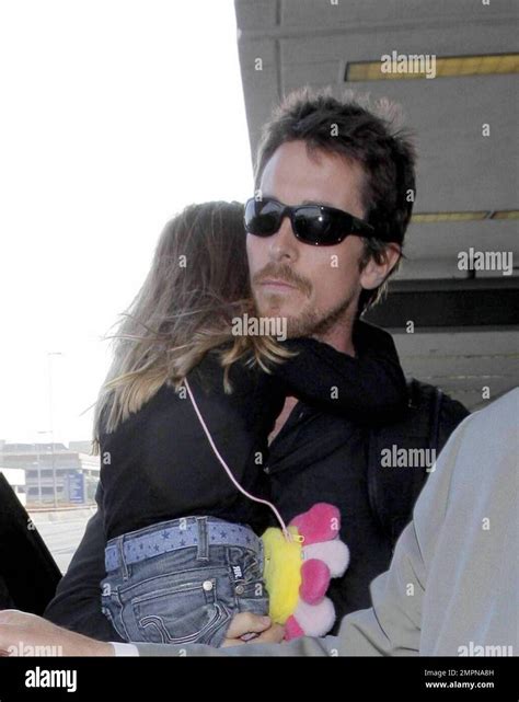 L'acteur Christian Bale porte sa fille Emmeline alors qu'il arrive avec ...