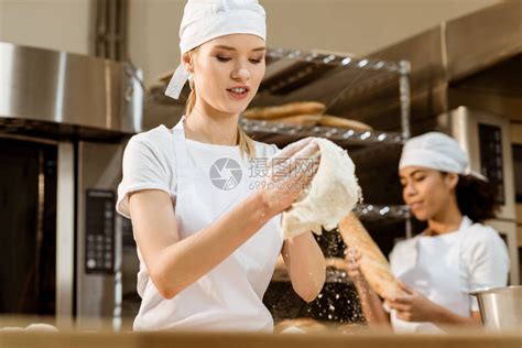 年轻女面包师在烘烤制造时用腰果高清图片下载-正版图片502936884-摄图网
