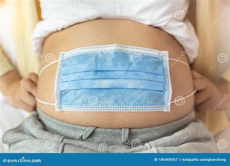 Pregnant Mother Use Face Mask Covering on Her Abdomen for Protecting Fetus or Baby from ...