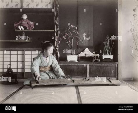 Young woman playing a koto stringed musical instrument, Japan. Vintage ...
