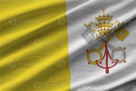 Vatican City State flag with big folds waving close up under the studio light indoors. The ...