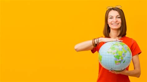 Vista frontale del globo felice della tenuta della donna con lo spazio ...