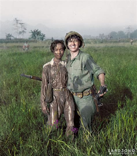 Unknown Dutch soldier smiling with Indonesian guerilla he captured earlier during a routine ...