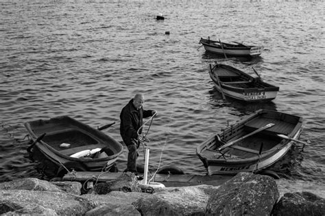 Man with Boats on Lakeshore in Black and White · Free Stock Photo
