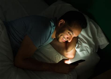 年轻男士深夜躺在床上玩手机高清图片下载-正版图片501698661-摄图网