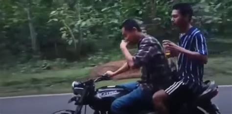 Two Men Drink Alcohol While Performing Stunts On Bike