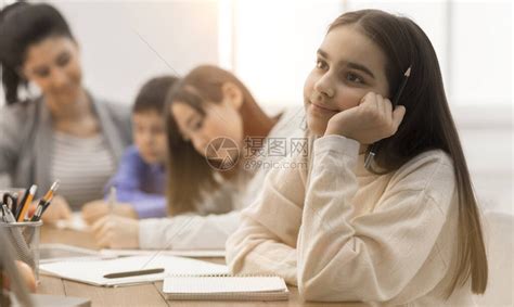 快乐女孩日梦与同学和背景教师坐在高清图片下载-正版图片504375249-摄图网
