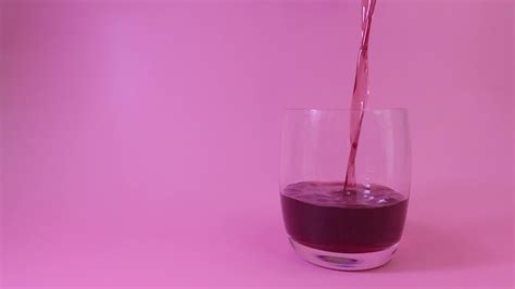 Pouring red grape juice into the glass white background, Fruit juices ...