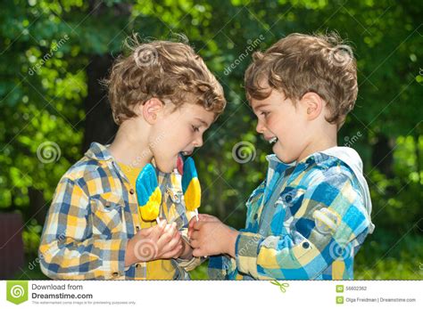 双男孩分享棒棒糖 库存照片. 图片 包括有 喜悦, 舌头, 蓝色, 衬衣, 森林, 欢欣, 格子花呢披肩 - 56602362