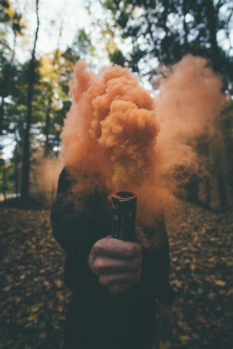 Person Holding Orange Smoke Bomb · Free Stock Photo