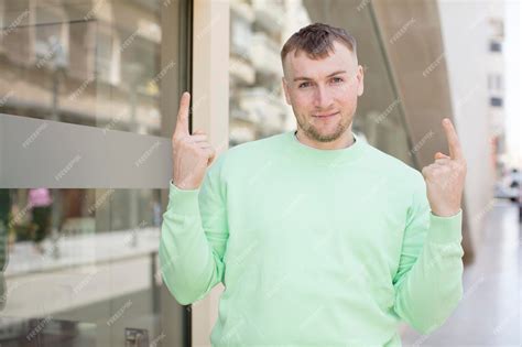 Premium Photo | Handsome man feeling awed and open mouthed pointing ...