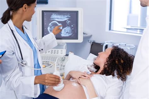 Technician performing ultrasound on pregnant woman - Imaging Center, Minimally Invasive Services