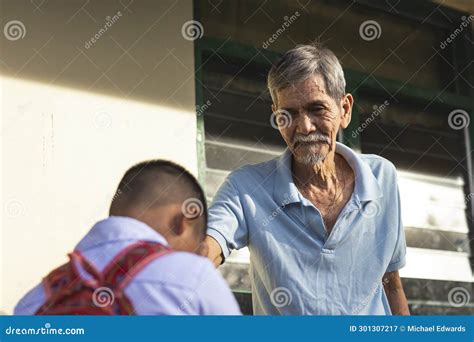 A Young School Boy Pays Respect To His Grandfather by Doing the Mano Po ...