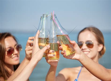 在海滩上喝酒的快乐年轻女性的特写高清摄影大图-千库网