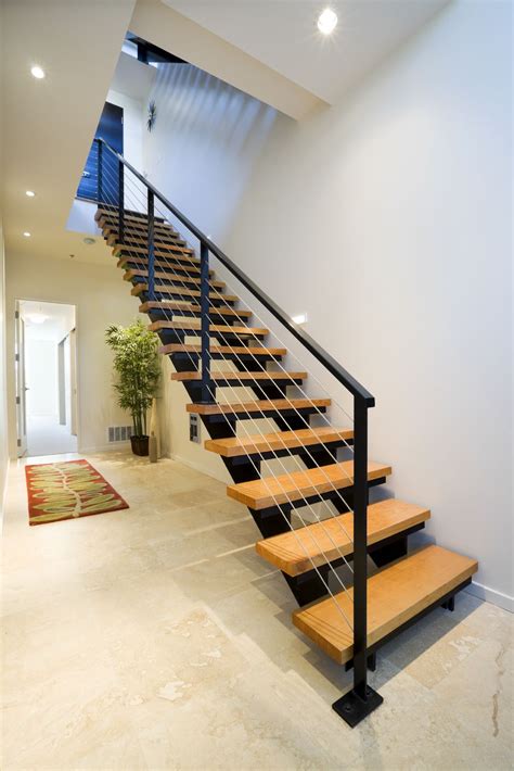 This modern staircase has a metal frame with natural wood treads. The ...