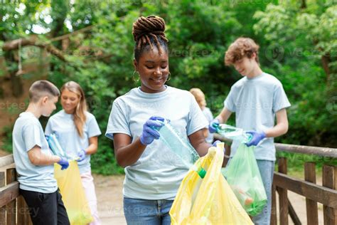 A multiethnic group of people, cleaning together in a public park, are protecting the ...