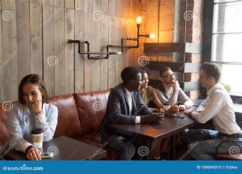Diverse Young Friends Ignoring Sad Girl Sitting Alone in Cafe Stock ...