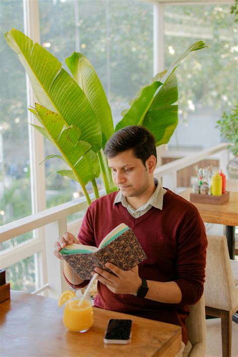 Man Sitting on Chairs and Reading · Free Stock Photo