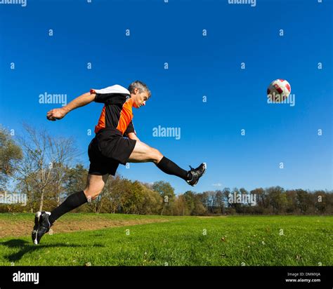 Soccer player kicking ball Stock Photo - Alamy