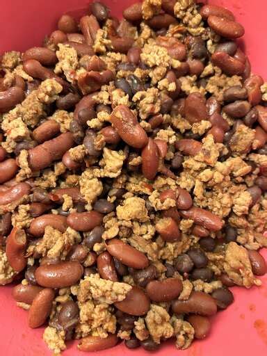 A bowl of Laura's quick slow cooker turkey chili, topped with shredded cheese, sliced green onions,