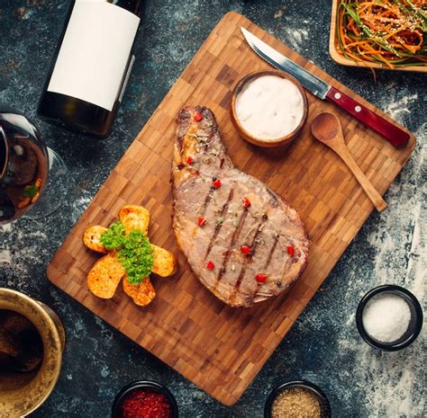 Fried rib eye steak on wooden board | Free Photo
