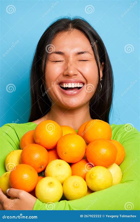 A Portrait of Amazed Asian Woman Holds a Bunch of Fresh Oranges and ...